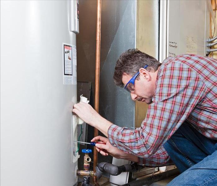 Image of a person performing maintenance on a water heater