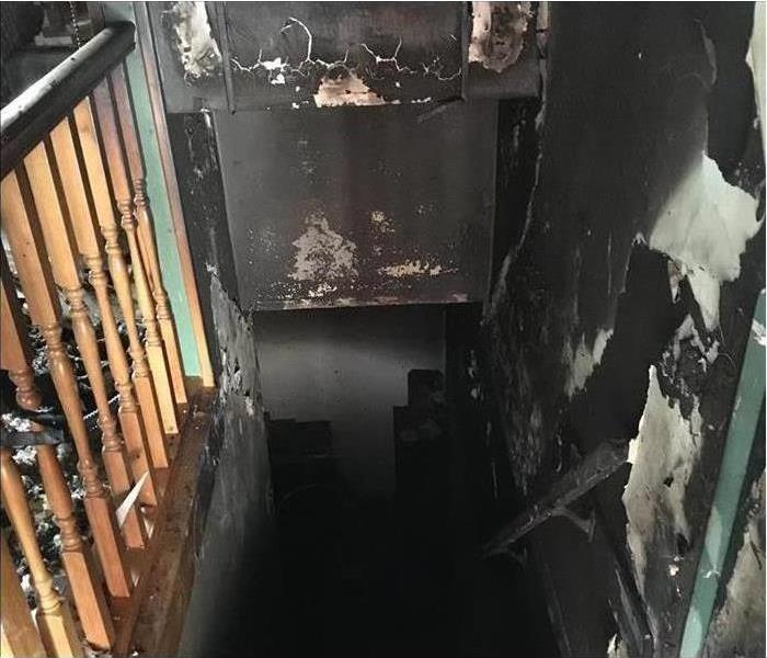 Walls of wooded stairwell damage with smoke and fire damage. 
